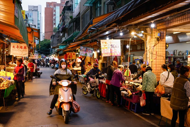 &copy; Reuters. A woman on a motorbike rides at a morning market in Taipei, Taiwan January 10, 2024. REUTERS/Ann Wang