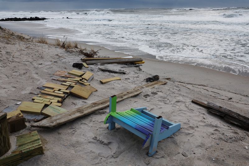 &copy; Reuters. A chair lays on the sand with other debris as waves rush the beach during the pass of a winter storm in Lido Beach, New York, U.S., January 10, 2024.  REUTERS/Shannon Stapleton