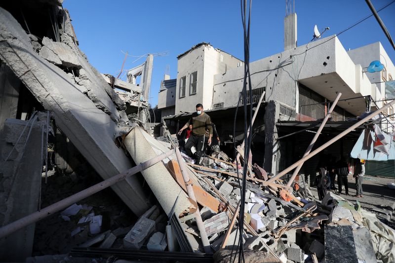© Reuters. Palestinians inspect the site of an Israeli strike, amid the ongoing conflict between Israel and the Palestinian Islamist group Hamas, in Deir Al-Balah in the central Gaza Strip January 10, 2024. REUTERS/Mohammed Al-Masri