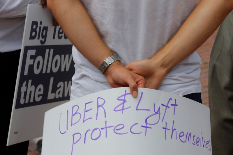 &copy; Reuters. FILE PHOTO: A man holds a sign reading ?Uber and Lyft Protect Themselves? at a demonstration opposing a ballot campaign by companies such as Uber, Lyft and Door Dash to exempt their companies from some labor laws, outside the Massachusetts Statehouse in B