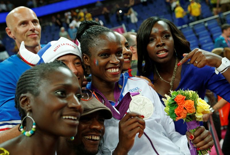 &copy; Reuters. Emilie Gomis comemora medalha de prata com a família durante cerimônia de vitória na North Greenwich Arena durante os Jogos Olímpicos de Londres 2012
11/08/2012
REUTERS/Mike Segar