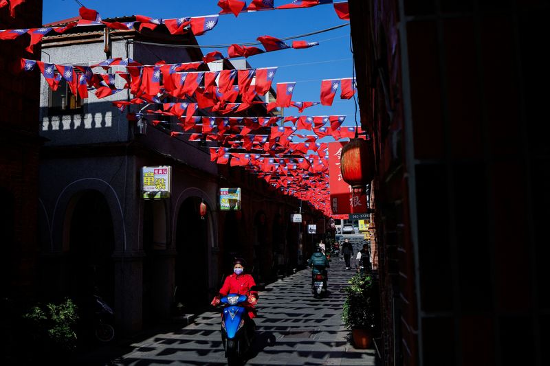 © Reuters. FILE PHOTO: People drive pass a street decorated with Taiwanese flags in Kinmen, Taiwan December 18, 2023. REUTERS/Ann Wang/File Photo