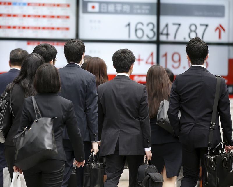 &copy; Reuters. People walk in front of an electronic board showing Japan's Nikkei average outside a brokerage in Tokyo, Japan, April 13, 2016.   REUTERS/Toru Hanai/File Photo