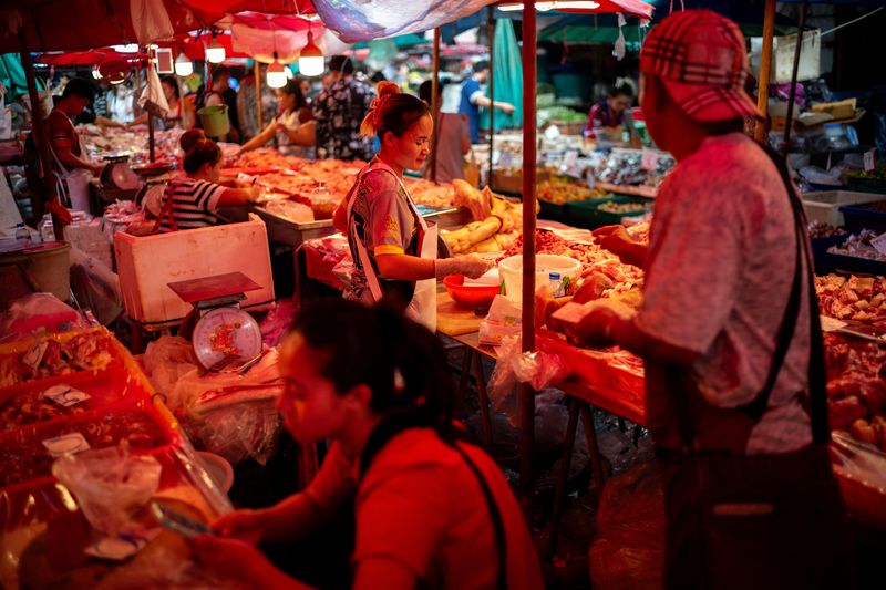 &copy; Reuters. Vendors sell pork at their stalls inside a market as Thailand is to inject $15.2 bln into economy next year through its digital wallet policy, in Bangkok, Thailand, October 2, 2023. REUTERS/Athit Perawongmetha