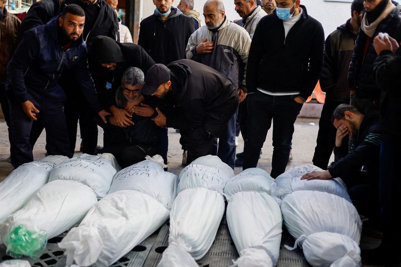 &copy; Reuters. أشخاص يبكون بجوار جثامين فلسطينيين قتلوا في غارات إسرائيلية في صورة التقطت رفح جنوب قطاع غزة يوم يوم الأربعاء. تصوير: محمد سالم رويترز.
