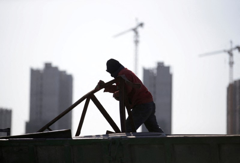 &copy; Reuters. FILE PHOTO: A man works near apartment blocks under construction on the outskirts of Beijing, China December 16, 2017. Picture taken December 16, 2017. REUTERS/Jason Lee/File Photo 