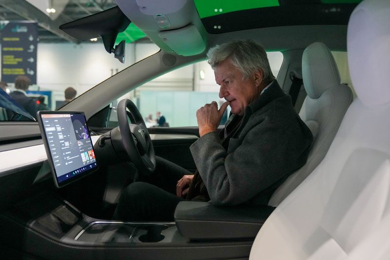 &copy; Reuters. A person inspects a Tesla car at The London EV Show, in London, Britain November 30, 2023. REUTERS/Maja Smiejkowska/File Photo