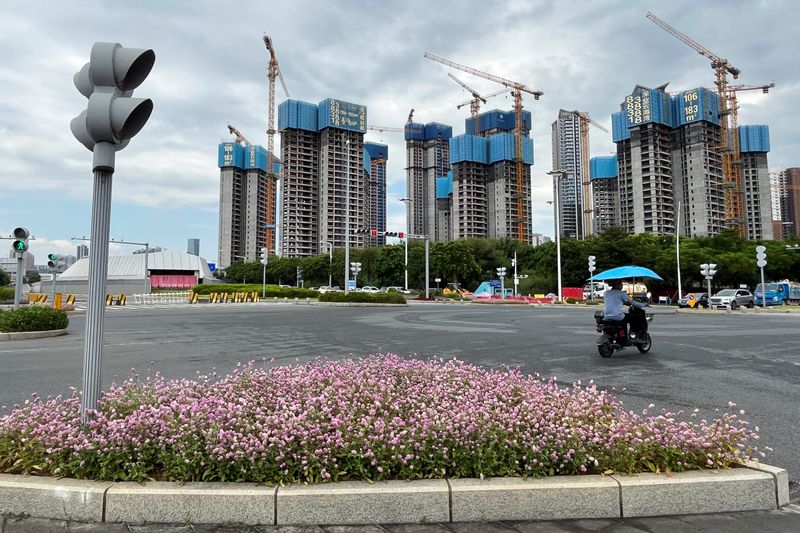 &copy; Reuters. A man rides a scooter past buildings under construction in Shenzhen's Qianhai new district, Guangdong province, China August 9, 2023. REUTERS/David Kirton/File Photo