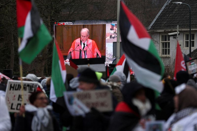 © Reuters. Imagen de una retransmisión en directo mostrada en una calle mientras manifestantes propalestinos protestan cerca del Tribunal Internacional de Justicia (TIJ) el día en que los jueces escuchan una petición de medidas de emergencia para ordenar a Israel que detenga sus acciones militares en Gaza, en La Haya, Países Bajos 11 de enero de 2024. REUTERS/Thilo Schmuelgen  