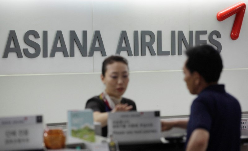 &copy; Reuters. FILE PHOTO: A staff of Asiana Airlines speaks to a passenger at Gimpo Airport in Seoul August 8, 2013. REUTERS/Kim Hong-Ji/File Photo 