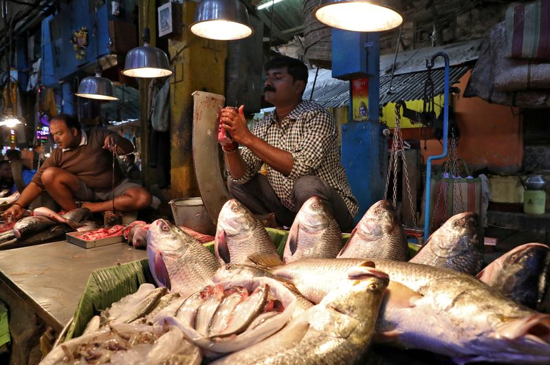 &copy; Reuters. FILE PHOTO: A vendor cuts fish for a customer at a wholesale fish market in Kolkata, India, February 12, 2020. REUTERS/Rupak De Chowdhuri/File Photo
