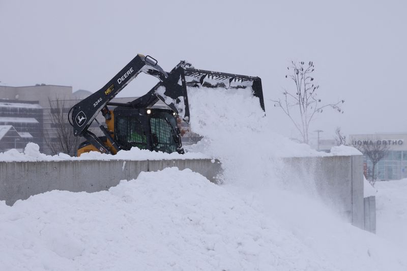 © Reuters. A worker removes snow from a parking structure after a blizzard left several inches of snow in Des Moines, Iowa, U.S., January 13, 2024. REUTERS/Jeenah Moon