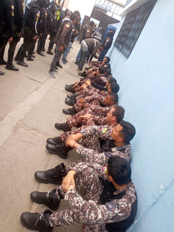 &copy; Reuters. موظفو أحد السجون في أمباتو بالإكوادور كانوا محتجزين من قبل بعض نزلائه يجلسون بعد أن حررتهم الشرطة والجيش. نشرت الصورة يوم السبت من قبل القوا