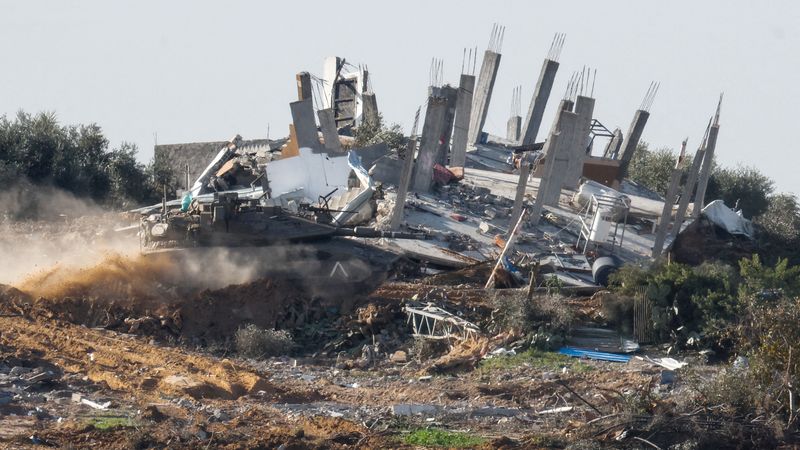 &copy; Reuters. دبابة تناور إلى جانب مبنى مدمر بوسط غزة خلال الصراع الدائر بين إسرائيل وحماس كما شوهدت من إسرائيل يوم السبت. تصوير: عامير كوهين - رويترز.