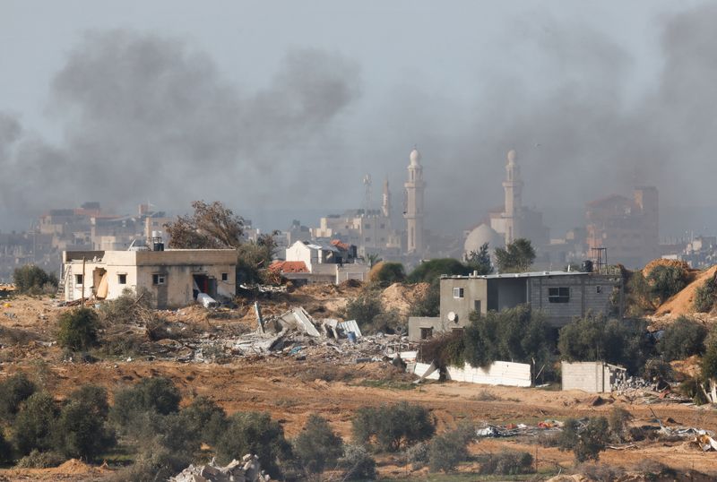 © Reuters. دخان يتصاعد بوسط غزة بالقرب من الحدود بين إسرائيل وغزة كما شوهد من إسرائيل يوم السبت. تصوير: عامير كوهين - رويترز.