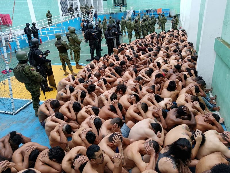 © Reuters. Prisoners sit huddled, guarded by police and armed forces, during an operation said to be at Turi prison to regain control for the prison, in Cuenca, Ecuador, given as January 14, 2024 in this image obtained from social media. Armed Forces of Ecuador via REUTERS