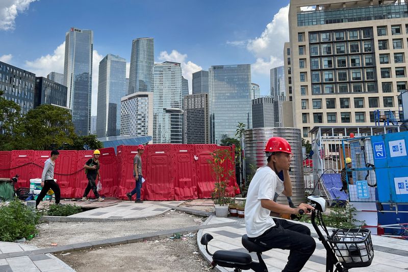 &copy; Reuters. FILE PHOTO: Workers walk past an under-construction area with completed office towers in the background, in Shenzhen's Qianhai new district, Guangdong province, China August 25, 2023. REUTERS/David Kirton/File Photo