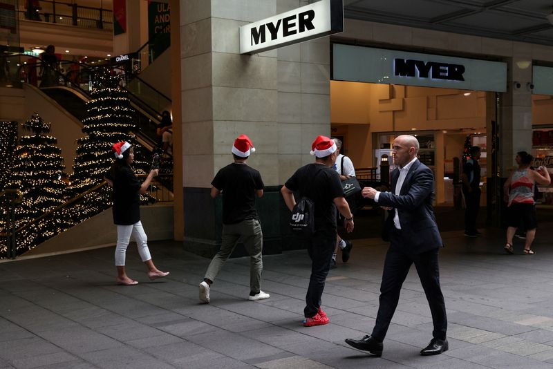 &copy; Reuters. FILE PHOTO: People wearing Santa hats walk through a shopping plaza decorated for the holidays in the city centre of Sydney, Australia, December 17, 2020.  REUTERS/Loren Elliott/File Photo