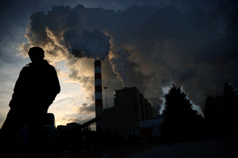 &copy; Reuters. FILE PHOTO: A man walks as Smoke and steam billow from Belchatow Power Station, Europe's largest coal-fired power plant powered by lignite, operated by Polish utility PGE, in Rogowiec, Poland, November 22, 2023. REUTERS/Kacper Pempel/File Photo