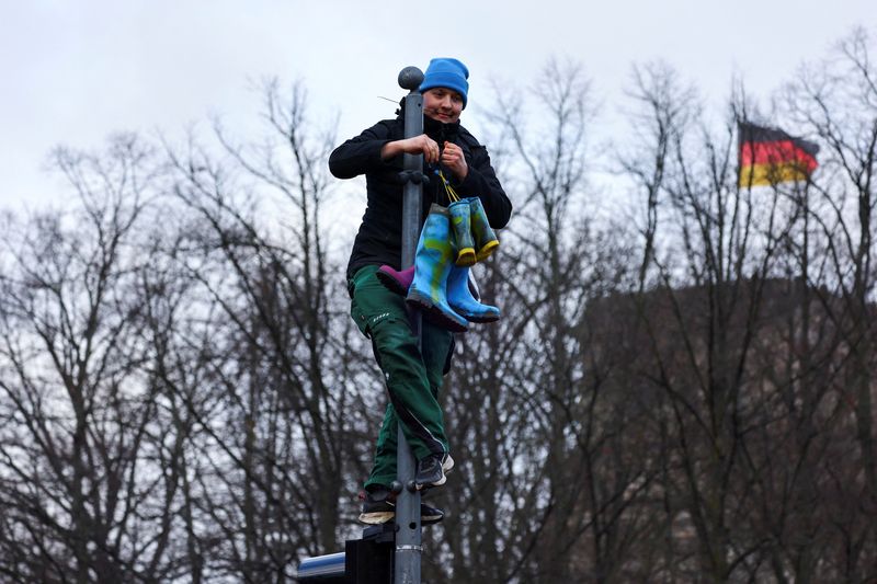 &copy; Reuters. Una manifestante tiene degli stivali su un palo durante le proteste degli agricoltori tedeschi davanti alla Porta di Brandeburgo a Berlino, Germania, 15 gennaio 2024. REUTERS/Fabrizio Bensch      TPX IMAGES OF THE DAY