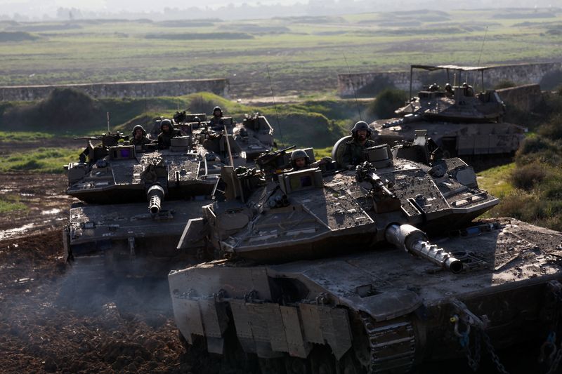 &copy; Reuters. Israeli soldiers ride tanks while moving out of the Gaza Strip, amid the ongoing conflict between Israel and the Palestinian Islamist group Hamas, as seen from southern Israel, January 15, 2024. REUTERS/Amir Cohen