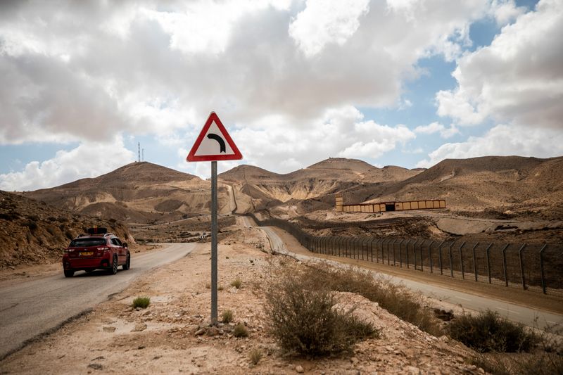 © Reuters. سيارة إسرائيلية تسير في طريق تراقبه نقطة تفتيش  عسكرية مصرية على الحدود المصرية الإسرائيلية كما شوهدت من جنوب إسرائيل في صورة من أرشيف رويترز .  