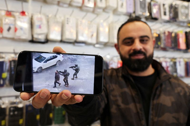 &copy; Reuters. El palestino Bahaa Abu Ras, que fue utilizado como escudo humano por las tropas israelíes durante una redada, muestra un video del incidente en su móvil en Dura, cerca de Hebrón, en la Cisjordania ocupada por Israel. 15 de enero de 2024. REUTERS/Mussa 