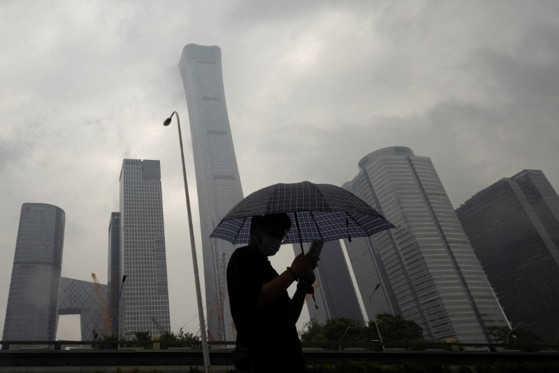 &copy; Reuters. A man walks in the Central Business District on a rainy day, in Beijing, China, July 12, 2023. REUTERS/Thomas Peter/File Photo