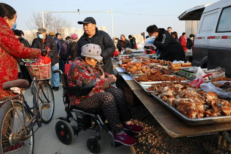 &copy; Reuters. Elderly people chat next to a food stall at an outdoor market in Beijing, China January 12, 2024. REUTERS/Florence Lo/File Photo