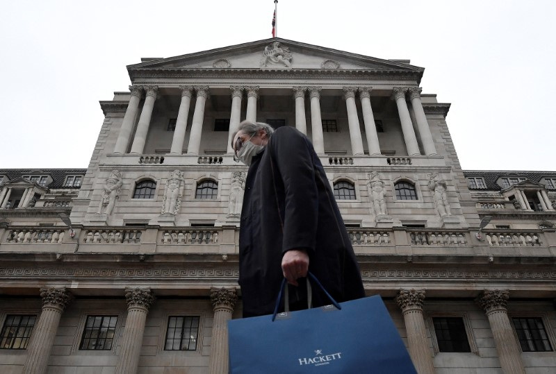 &copy; Reuters. A man wearing a protective face mask walks past the Bank of England (BoE), after the BoE became the first major world's central bank to raise rates since the coronavirus disease (COVID-19) pandemic, in London, Britain, December 16, 2021. REUTERS/Toby Melv