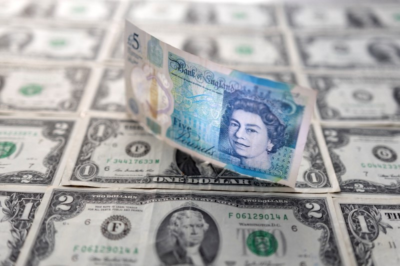&copy; Reuters. Una banconota da 5 sterline inglesi sopra a diverse banconote in dollari statunitensi. REUTERS/Dado Ruvic/