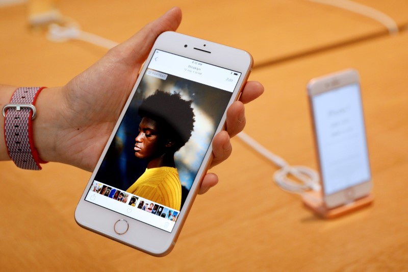 &copy; Reuters. Un employé d'Apple présente un iPhone 8 Plus dans une boutique du groupe à Singapour. /Photo d'archives/ REUTERS/Edgar Su