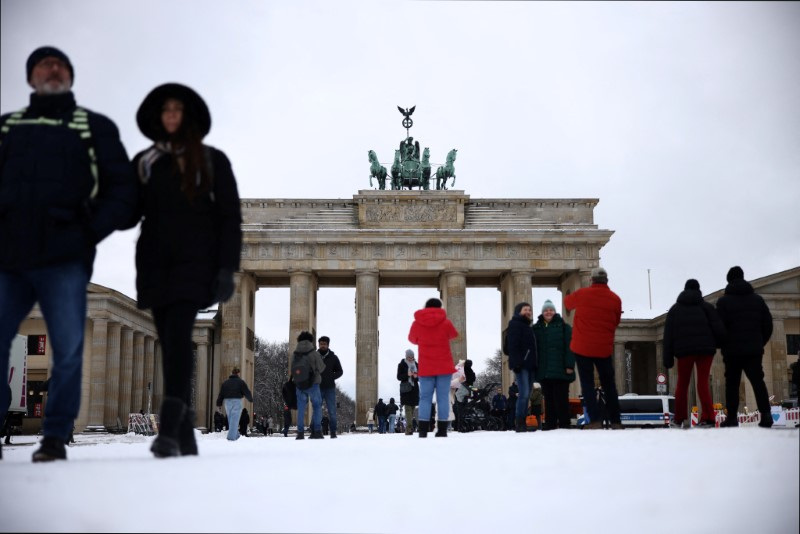 &copy; Reuters. Des personnes marchent dans la neige devant la porte de Brandebourg à Berlin, en Allemagne. /Photo prise le 16 janvier 2024/REUTERS/Liesa Johannssen