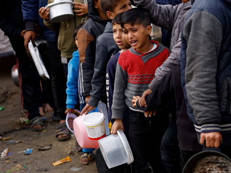 &copy; Reuters. Un niño reacciona mientras los palestinos esperan para recibir comida en medio de la escasez de suministros alimentarios, en Rafah, en el sur de la Franja de Gaza. 17 de enero de 2024. REUTERS/Mohammed Salem  