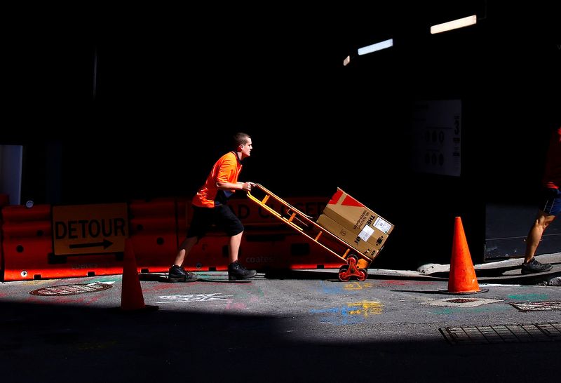 &copy; Reuters. A worker pushes a trolley loaded with goods past a construction site in the central business district (CBD) of Sydney in Australia, March 15, 2018. REUTERS/David Gray/File Photo