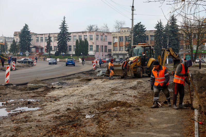 © Reuters. Workers reconstruct a street, which was damaged on the first months of Russia's attack on Ukraine in the town of Trostianets, Sumy region, Ukraine November 3, 2023. REUTERS/Valentyn Ogirenko