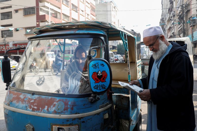&copy; Reuters. Varios hombres leen periódicos, después de que el Ministerio de Asuntos Exteriores de Pakistán dijera que el país llevó a cabo ataques dirigidos contra objetivos separatistas baluchíes dentro de Irán, a lo largo de una carretera en Karachi, Pakist