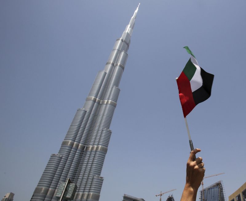 &copy; Reuters. شخص بيده علم الإمارات أمام برج خليفة في صورة من أرشيف رويترز.