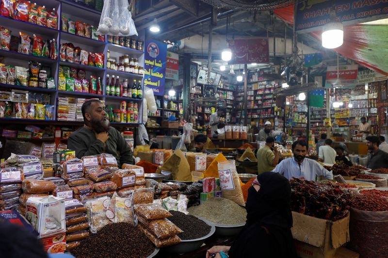 &copy; Reuters. A customer speaks with a shopkeeper selling grocery items at a market in Karachi, Pakistan June 8, 2023. REUTERS/Akhtar Soomro