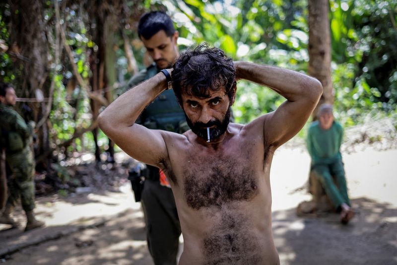 © Reuters. Members of the Special Inspection Group from the Brazilian Institute of Environment and Renewable Natural Resources (IBAMA) detain an illegal miner during an operation against illegal mining in Yanomami Indigenous land, Roraima state, Brazil, December 5, 2023. A year after President Luiz Inacio Lula da Silva declared a humanitarian crisis among the Yanomami and vowed zero tolerance for illegal mining, environmental enforcers warn that Brazil is jeopardizing last year's hard-won progress, when about 80 percent of roughly 20,000 wildcatters were ousted from the Portugal-sized reservation. As the Brazilian military has rolled back its support for the government crackdown, the gold-seeking miners have come back, they say, making fresh incursions into Yanomami land. REUTERS/Ueslei Marcelino 