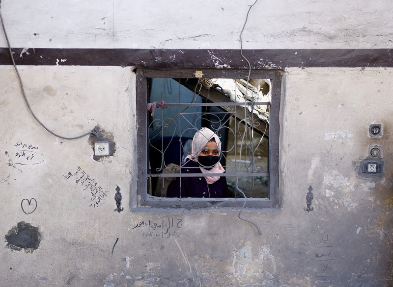 &copy; Reuters. Una donna osserva il luogo di un attacco israeliano a una casa, nel corso del conflitto in corso tra Israele e il gruppo islamista palestinese Hamas, a Rafah, nel sud della Striscia di Gaza, il 18 gennaio 2024. REUTERS/Mohammed Salem
