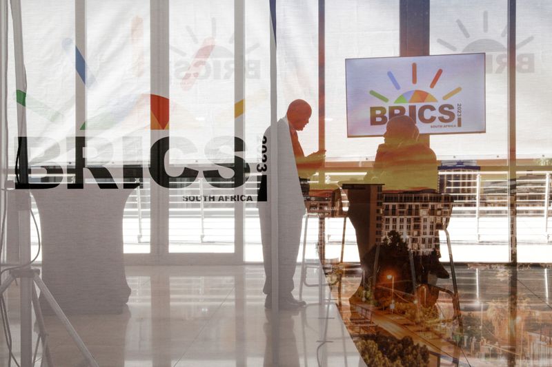 &copy; Reuters. Les délégués interagissent à côté du logo des BRICS lors du sommet 2023 au Sandton Convention Centre à Johannesburg, en Afrique du Sud. /Photo prise le 23 août 2023/REUTERS/Gianluigi Guercia
