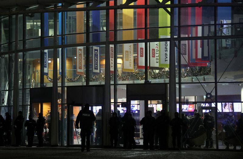 &copy; Reuters. Police stand outside the Polish public television TVP building as protesters and Law and Justice politicians gather after Poland's new government took a public news channel off the air and dismissed executives from state media to restore "impartiality," t