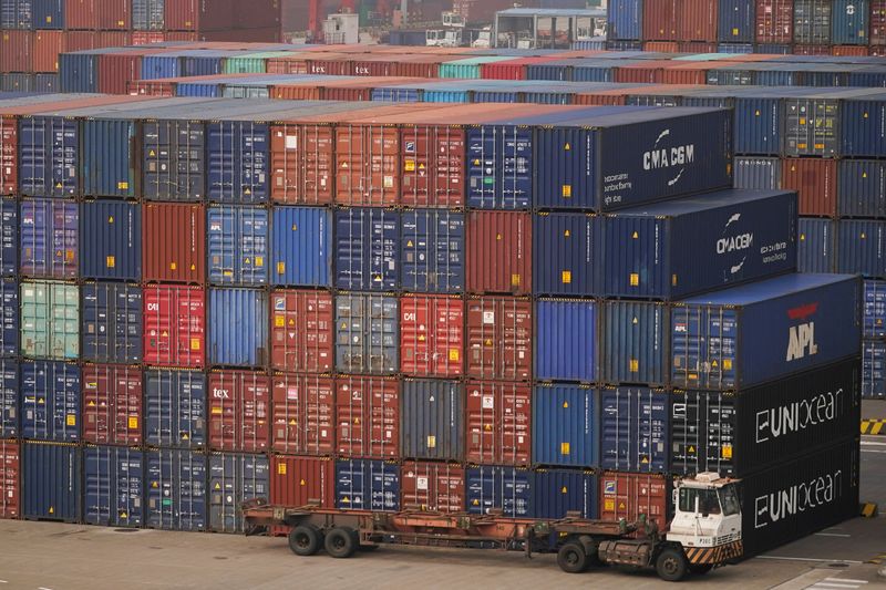 &copy; Reuters. FILE PHOTO: A truck is seen next to containers at the Yangshan Deep Water Port in Shanghai, China, January 13, 2022. Picture taken January 13, 2022. REUTERS/Aly Song/File Photo