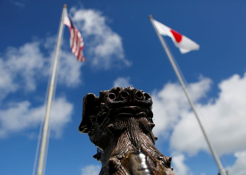 &copy; Reuters. The U.S. (L) and Japanese national flags are hoisted next to a traditional Okinawan Shisa statue at the U.S. Marine's Camp Foster in Ginowan, on the southern island of Okinawa, Japan June 18, 2016. REUTERS/Tim Kelly/file photo
