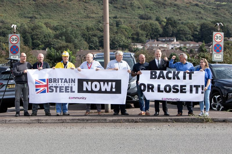© Reuters. FILE PHOTO: Protesters hold signs outside Tata Steel, amid a government announcement about steel industry investments, in Port Talbot, Britain September 15, 2023. REUTERS/Joann Randles/File Photo