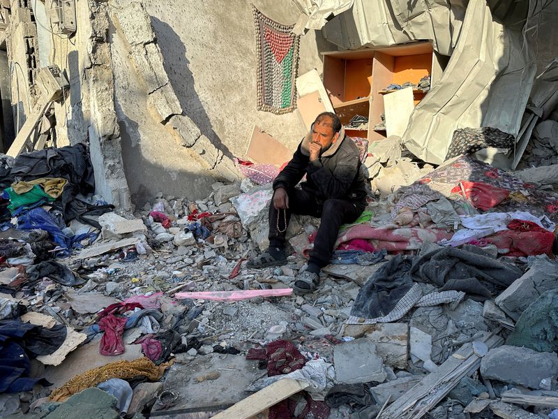 &copy; Reuters. رجل فلسطيني جالسا وسط حطام منزله الذي دمرته الغارات الإسرائيلية في مدينة رفح بجنوب غزة يوم الخميس. تصوير: فادي شناعة - رويترز.