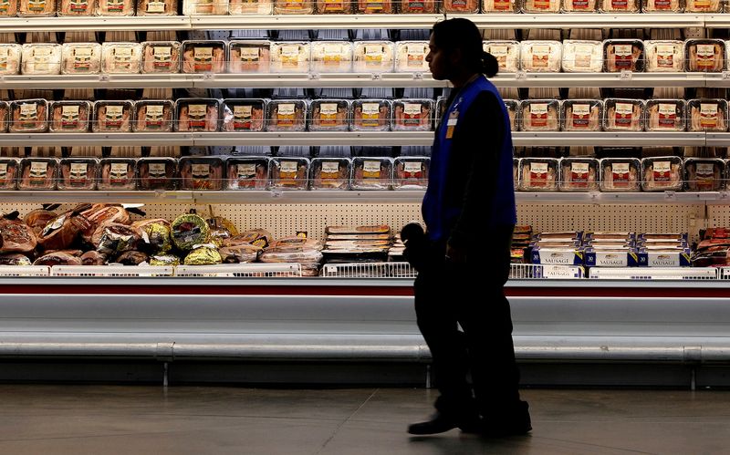 © Reuters. A employee walks by a meat cooler in the grocery section of a Sam's Club during a media tour in Bentonville, Arkansas June 5, 2014. REUTERS/Rick Wilking/File photo