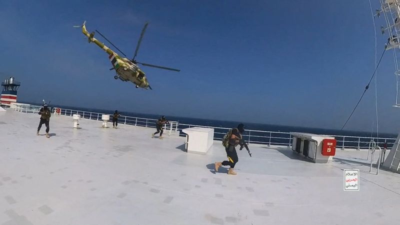 &copy; Reuters. مروحية عسكرية تابعة للحوثيين تحلق فوق سفينة الشحن جالاكسي ليدر بينما يسير مقاتلون حوثيون على سطح السفينة في البحر الأحمر في صورة نُشرت يوم 2