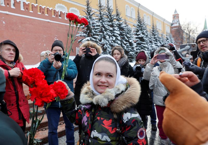 © Reuters. Maria Andreeva, whose husband was mobilised in October 2022 to join the Russian armed forces involved in a military campaign in Ukraine, lays flowers at the Tomb of the Unknown Soldier by the Kremlin wall in Moscow, Russia, January 20, 2024. Andreeva is an active member of Russian women's movement 